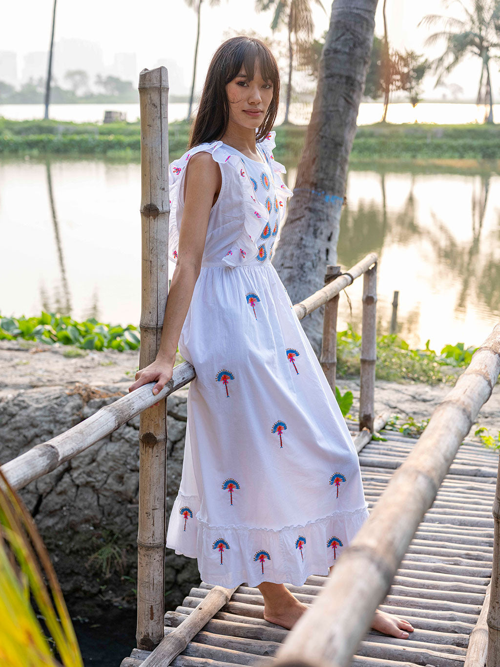 Model wearing the fitted Pernilla embroidered midi dress in organic cotton, showcasing the breezy summer silhouette.