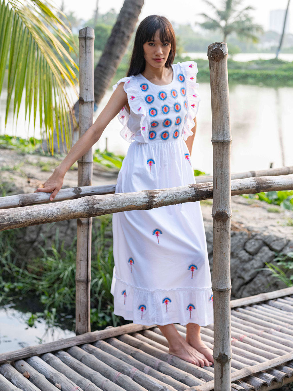 Model wearing the fitted Pernilla embroidered midi dress in organic cotton, showcasing the breezy summer silhouette.
