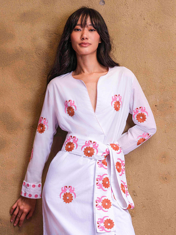 Detailed shot of the fixed wrap-effect neckline and the vibrant Gujarat bird embroidery on the white cotton bodice.