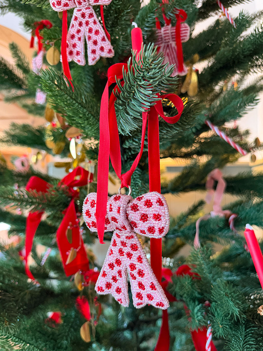 Decorative red and white bow ornaments on a Christmas tree.