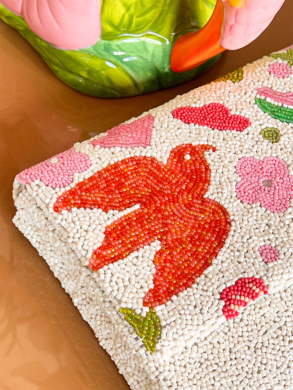 Close-up of a beaded purse with a red bird design