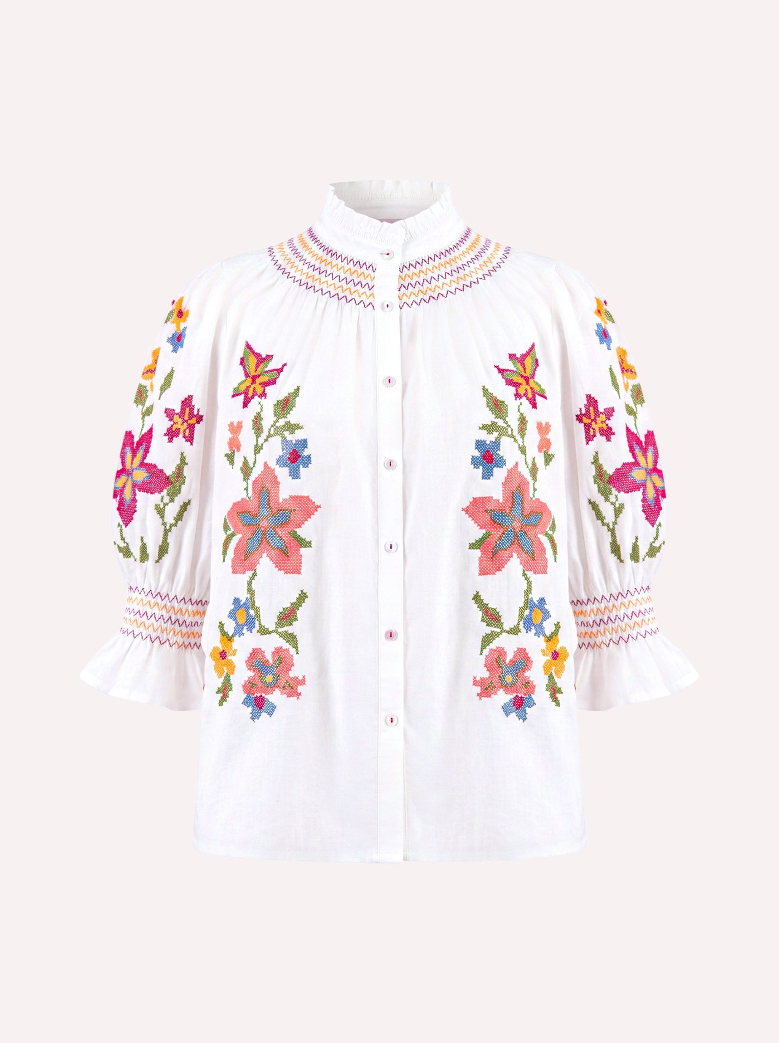 White button-up blouse with colorful floral embroidery on the front and sleeves, featuring a high pleated collar and ruffled three-quarter sleeves, shown on a light beige background.