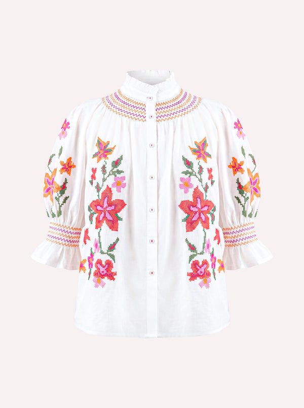 White organic cotton Nimo Bergamot Blouse with colorful floral cross-stitch embroidery.