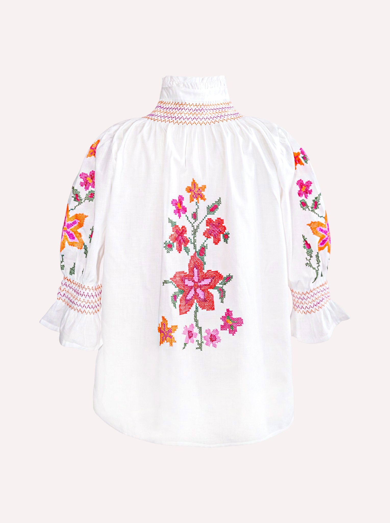 Back of the organic cotton Nimo Bergamot Blouse with colorful floral cross-stitch embroidery.