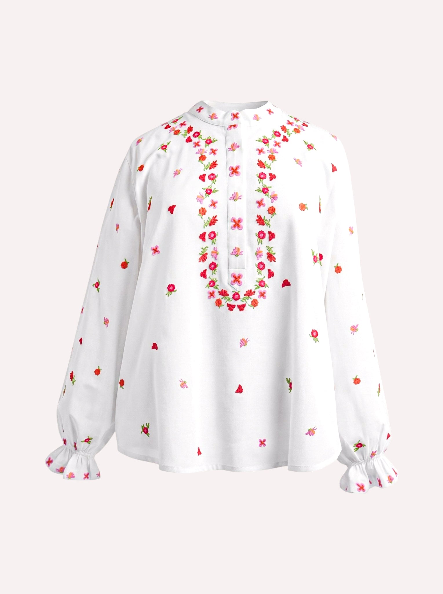 A white long-sleeve blouse with colorful floral embroidery around the neckline and scattered across the fabric, featuring ruffled cuffs, shown against a light beige background.