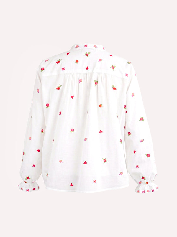 A white long-sleeve blouse with a delicate all-over embroidered pattern of small red flowers, green leaves, and pink hearts, shown from the back against a light off-white background.