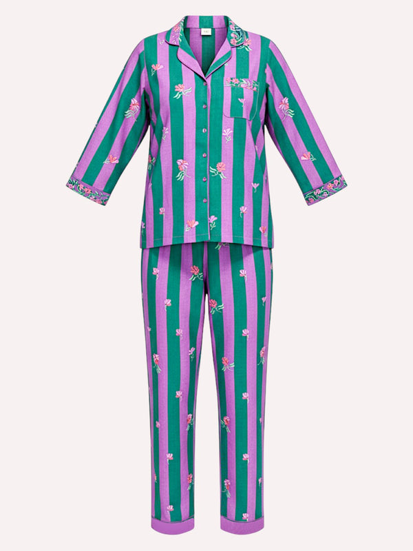 A luxury Nimo With Love two-piece pajama set featuring a long-sleeve button-up top and matching pants with vertical pink and teal stripes and small floral prints, shown on a light beige background.