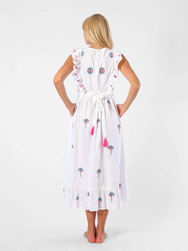 Back view of the Pernilla dress showing the adjustable tie-back with fuchsia tassels and intricate palm tree embroidery.