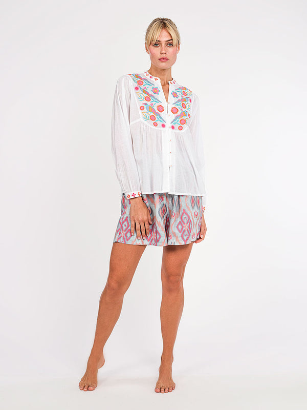 Model wearing the loose and easy-fitting Catnep summer tunic blouse in organic cotton, styled with patterned shorts for a luxury resort look.