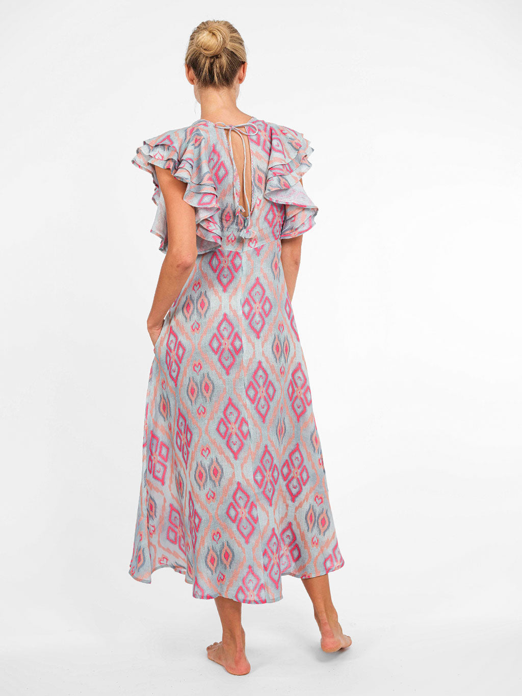 The back of the Belladonna dress showcasing the V-neckline, adjustable ties, and layered sculptural sleeves.