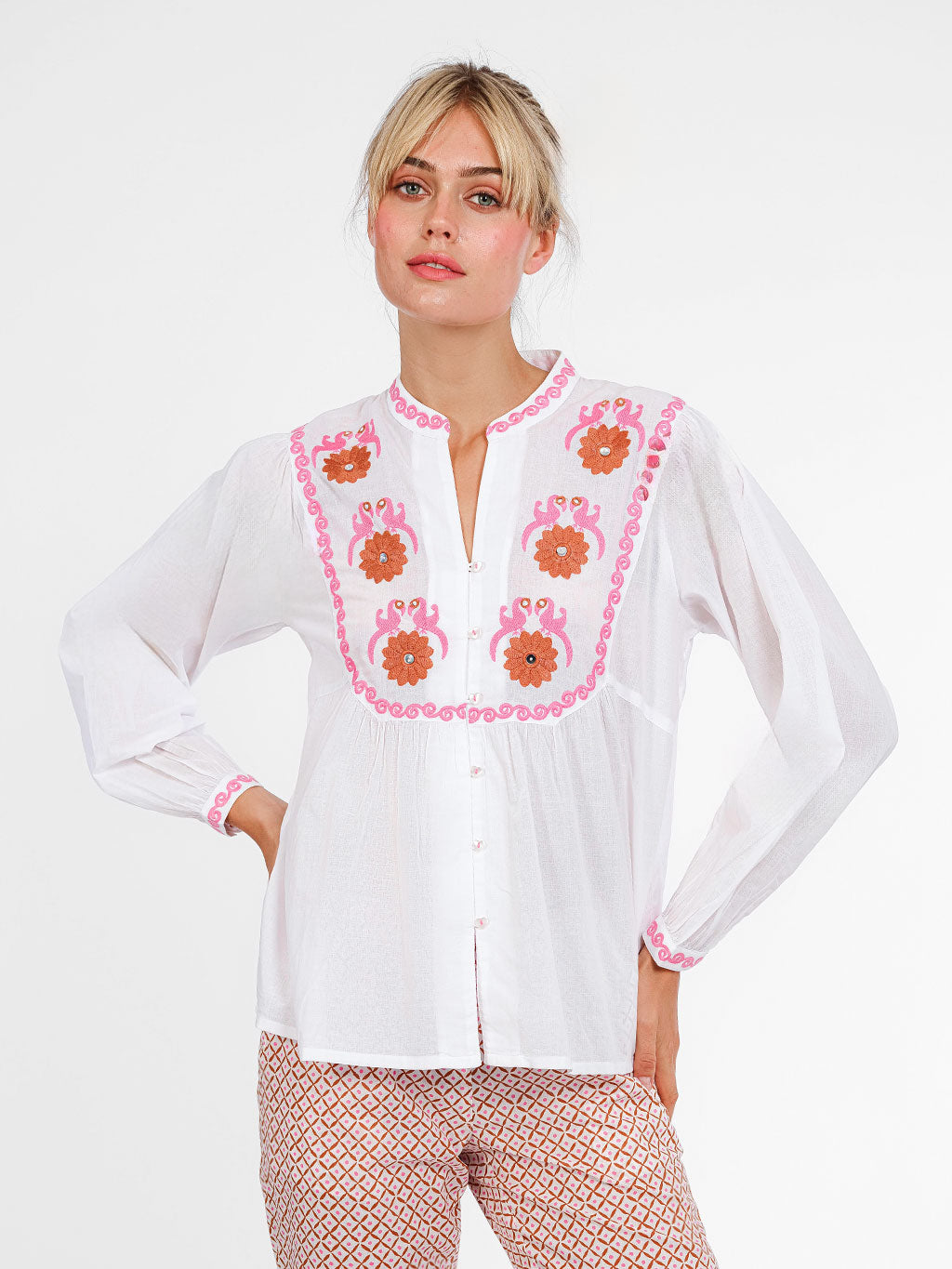 White organic cotton Catnep blouse by Nimo With Love featuring vibrant bird and floral embroidery on the front yoke.